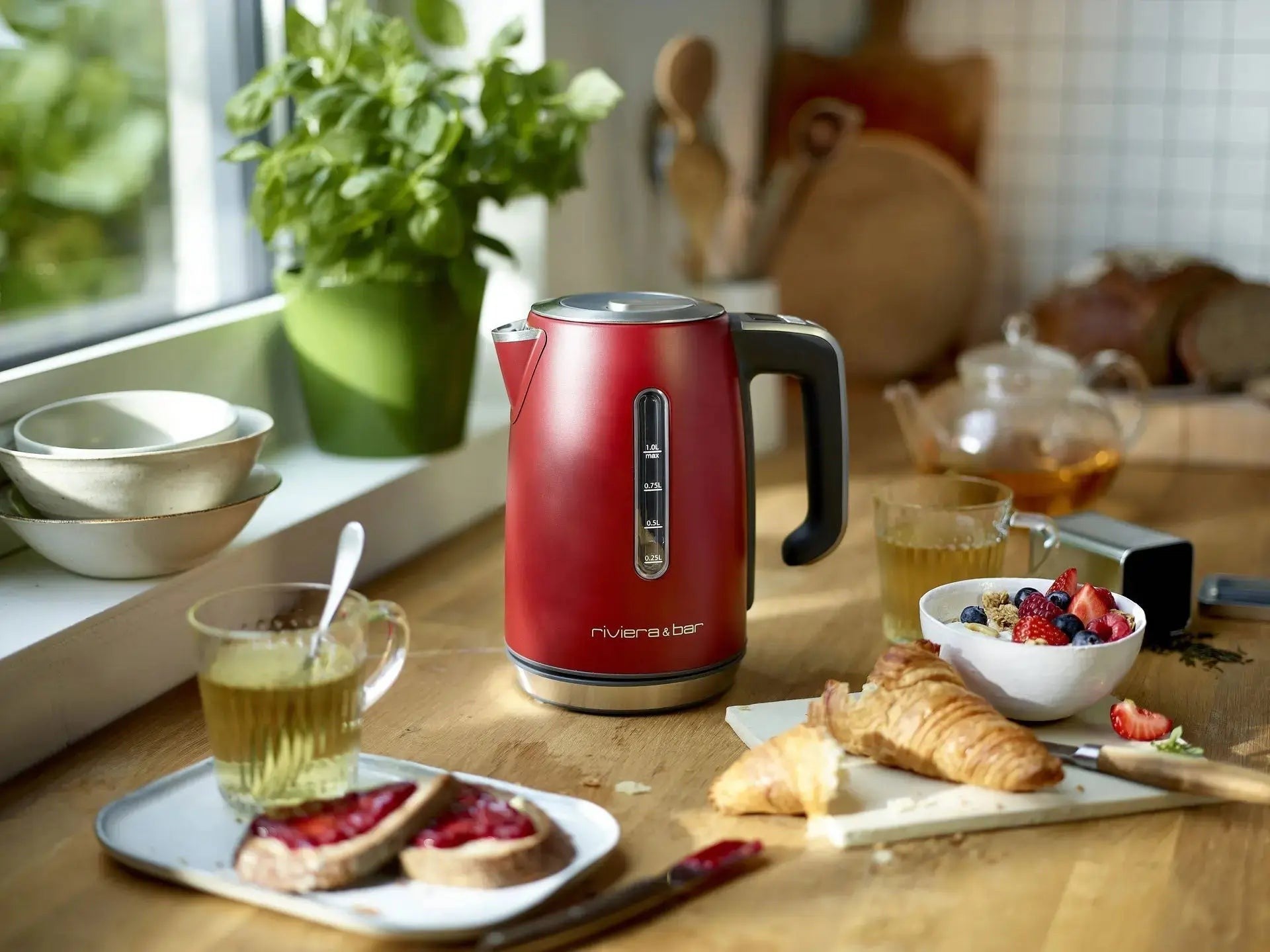 Rode waterkoker op ontbijttafel.