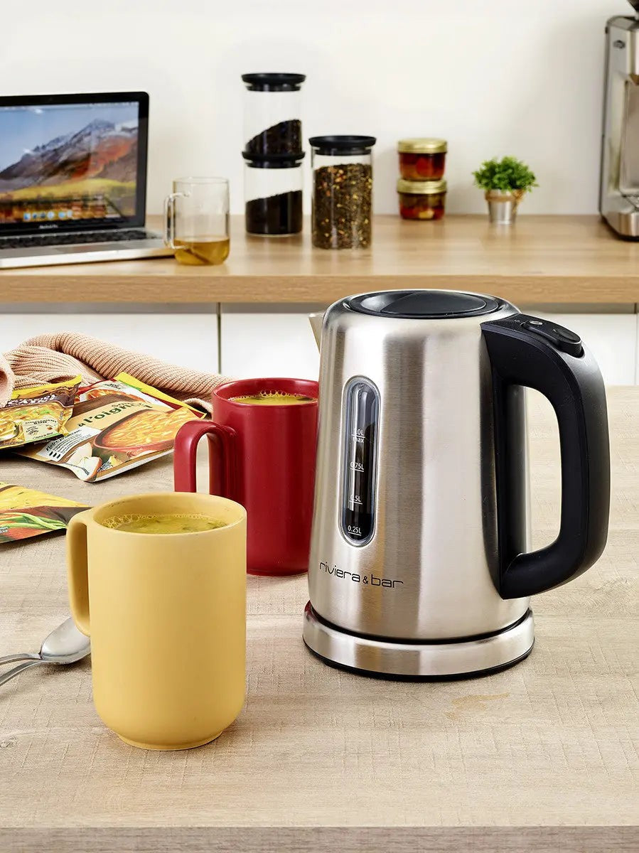 Roestvrijstalen elektrische waterkoker, gekleurde kopjes, lichte keuken.