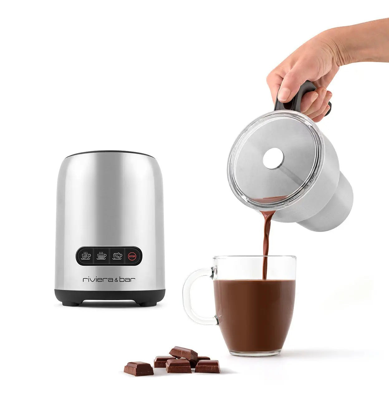 Roestvrijstalen elektrische chocolademaker giet warme chocolademelk in een glazen beker, met chocoladetaartjes in de buurt.