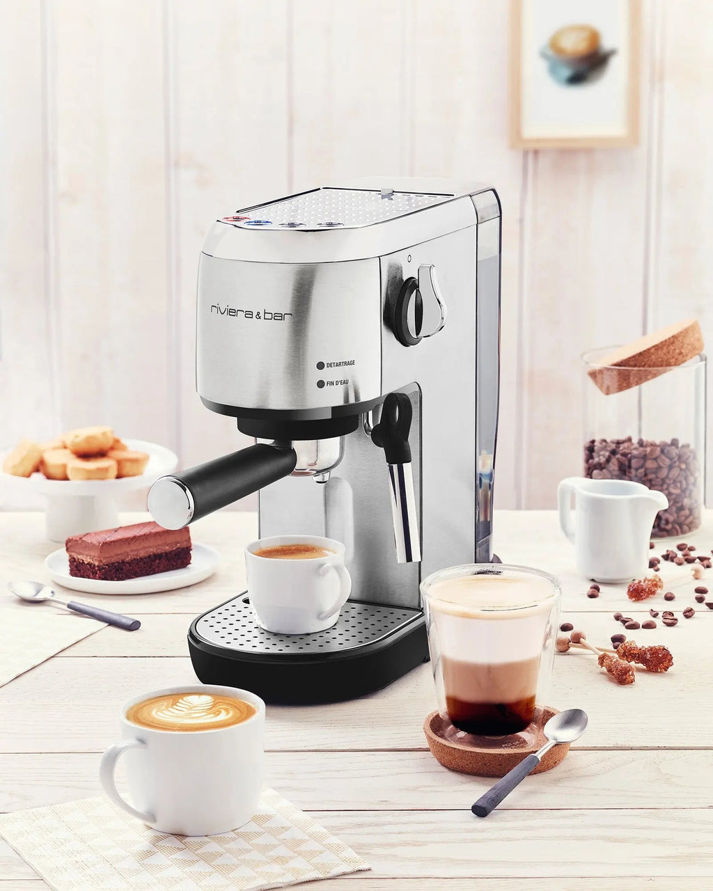 Roestvrijstalen espressomachine Riviera & Bar met koffiekopjes en gebak.