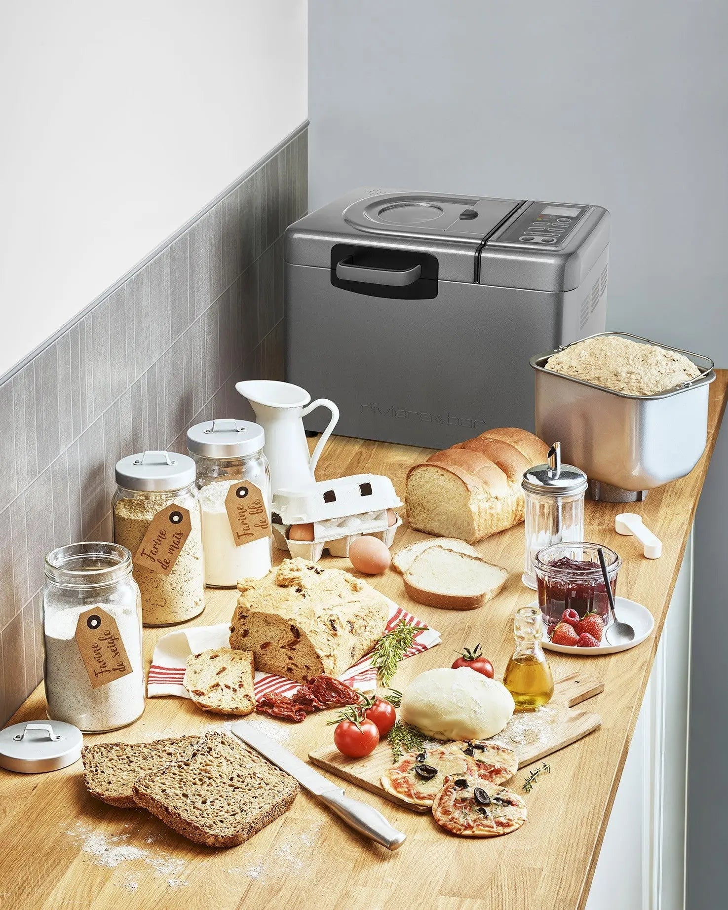 Keuken met broodmachine, verse ingrediënten, brood en pizza.