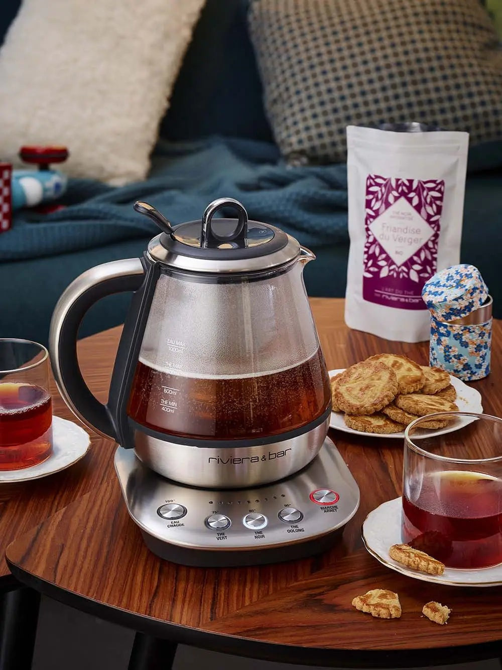 Glazen en roestvrijstalen elektrische theepot, koekjes, theezakje.